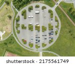 Park top down urban style parking symmetrical landscape. Road infrastructure and green plants nature overhead top down aerial drone view. Vehicle parking lot.