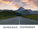 Small photo of Road leading towards Mount Kazbegi. Mount Kazbek or Mount Kazbegi is a dormant stratovolcano and one of the major mountains of the Caucasus, located on the Russian-Georgian border.