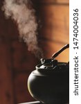 Small photo of Silhouette of a boiling kettle. Steam comes out of the tea spout. The smoke from the chimney. A powerful jet of steam. Blow off steam!