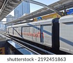 Small photo of BANGKOK, THAILAND - DECEMBER 7, 2019: Bangkok Skytrain (BTS) stops at the station in the city center in the morning. The advertisement text on the train says 'We are the doer.'