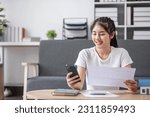 Small photo of Accounting. Focused young asian female sit on sofa pay domestic bills fees online using phone count amount payable on digital calculator. woman plan monthly budget at home office