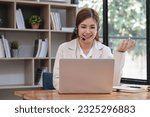 Small photo of Asian call center with headset and microphone working on her laptop. Female operator provide exceptional customer service. Supportive call center agent helping customer on inquiry. Enthusiastic