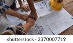 Small photo of A team of engineers who successfully planned work on a modern home construction project shook hands and congratulated the team on their success.