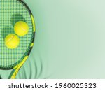 Tennis. Spring sport composition with yellow tennis ball and racket on a green background of tennis court with copy space. Sport and healthy lifestyle. The concept of outdoor game sports. Flat lay