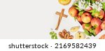 Small photo of Apple savior, holiday banner. New crop apples in a wooden box, apple jam, juice, pastries and wooden crucifixion on a white table with copy space. Sanctify products on apple savior. Soft focus style
