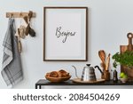 Stylish and cozy kitchen interior composition with mock up poster frame, black console, kitchen textile, teapot, plants and retro inspired accessories. Template. Autumn vibes.
