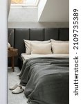 Small photo of Stylish composition of bedroom interior design with grey bed, beige bedclothes, wooden night table and elegant personal accessories. Details. Template.