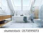 Stylish bathroom interior design with marble panels. Bathtub, towels and other personal bathroom accessories. Modern glamour interior concept. Roof window. Template.