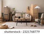 Small photo of Creative composition of living room interior with beige sofa, wooden coffee table, rattan sideboard, partition wall, lamp, carpet, stylish armchair and personal accessories. Home decor. Template