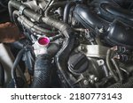 Small photo of Auto mechanic checking coolant fluid in the coolant fill hole.