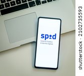 Small photo of Close up view of hand with smartphone and Spid - Sistema Pubblico Identita Digitale - logo on display. Laptop on background. Italian electronic signature. Milan, Italy - October 2021