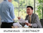 Small photo of Asian businessman manager in suit holding paperwork and strong talking for young employee with anger and serious gesture look like he comments as disagree or unacceptable for his project work