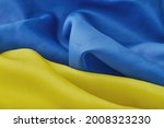 Fabric curved flag of Ukraine, UA. Blue and yellow colors. Close up shot, background
