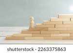 Small photo of Time is money idea. time concept with business man trying to outrun time. Make things better - Improvement Concept. wooden figure - man climbing the steps to success in image over white background