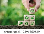 Small photo of Circular economy concept.Hand holding wooden block with green bokeh background.Eternity, endless and unlimited of Future business growth.Environmental sustainability and reduce pollution.