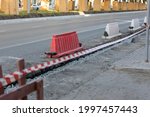 Small photo of Red and white barriers on a road repair site to constrain public movement for their safety. Security measures on a construction site. Mobile fencing