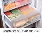 Plastic bags with different frozen vegetables in refrigerator. Food storage