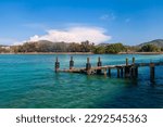 a picturesque pier at the rafai beach pier going under water with steps. Clear turquoise water and blue sky. Travel and recreation.