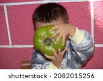 Small photo of baby posing with organic black sapote, which has vitamin a and c