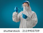 Small photo of A doctor in PPE and face shield holding test tube COVID-19 swab collection kit. Test tube for taking OP NP patient specimen sample, PCR DNA testing protocol process. PCR test concept.