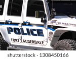 Small photo of Fort Lauderdale, Florida / USA - February 6 2019: Downtown Ft. Laud. Police Jeep in white and blue with LED lights, tinted windows, safety stickers, a tow wench and big fat tires for mud off roading