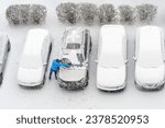 Winter parking lot cars under snow covered cars snow clearing. Parked cars snow removal. Cover winter yard above view top. Courtyard. Winter season. Cold weather conditions. Snowbound. Frosty morning