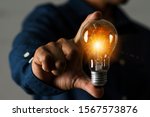 Small photo of A businessman holding a light bulb in his hand demonstrates the broad vision and concept of building a business that will grow with efficiency and stability.