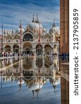 Small photo of Venice, Veneto, Italy - October 7, 2021: Piazza San Marco under water during the "acqua alta" flood tide with St. Mark's campanile reflected