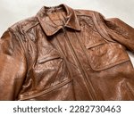 Vintage brown leather jacket on white background