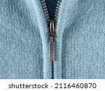 Small photo of Zip fastener of cashmere sweater macro. Fashionable blue jacket with zipper fastening for cold season. Half-zip jumper or pullover of fine soft wool jersey close-up. Casual stylish clothes. Front view