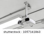 Small photo of A white overhead projector on ceiling indoors.