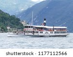 Small photo of Lake Garda, Brescia. Italy - September 3, 2018 : Italian paddle steamer with passengers, serenely makes it's way across the Lake towards Limone. Tree covered mountains in background