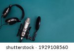 Small photo of Professional microphone with waveform and headphones on background banner. Podcast or recording studio background