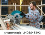 Small photo of Skilled cabinet maker cutting wood board with electric circular saw at woodworking sawmill. Professional cabinet maker use circular saw at sawmill factory. Wooden furniture production
