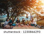 Group of young happy friends having pic-nic outdoors - People having fun and celebrating while grilling ata barbacue party in a countryside