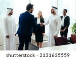 Small photo of Multiethnic western and middle eastern business team working together in an office of Dubai. Sales people and employees at work on new projects