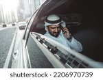 Arabic businessman looking at the skyline in Dubai from his limousine