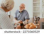 Senior couple having breakfast at home - Elderly people daily life in the moning