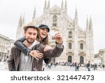 Happy tourists taking a self portrait with phone in front of Duomo cathedral,Milan - Couple traveling in Italy