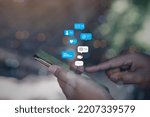 Small photo of Person using a social media marketing concept on mobile phone with notification icons of like, message, comment and star above smartphone screen.
