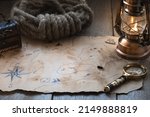 Small photo of Exploration, adventure and treasure hunt background, vintage map, kerosene lamp, chest, magnifier on wooden table. Columbus day.