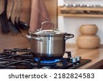Small photo of cook food in a saucepan, pan standing on a gas stove