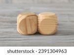 Small photo of Two abstract geometric wooden dice isolate on white rustic surface. Antagonism concept.