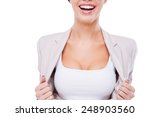 Willing to be the first in business. Close-up of happy young businesswoman taking off her jacket and showing her perfect cleavage while standing against white background