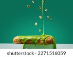 Small photo of Pistachio eclair is poured with glaze and sprinkled with pistachios on a green background.