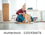DIY concept. Young woman repairing furniture at home, sitting on the floor.