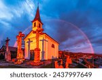 Small photo of The Chapel of Saint Thomas Becket in Szent Tamas lighten by a strong sunlight with a rainbow behind in rainy clouds in Esztergom, Hungary.