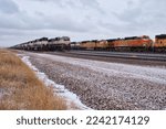 Small photo of Gillette, Wyoming - January 23, 2021: Trains on tracks next to dead grass on a cloudy cold winter day near Gillette, Wyoming.