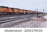 Small photo of Gillette, Wyoming - January 23, 2021: Long row of train engines being stored on a track outside Gillette, Wyoming on a cold cloudy winter day.