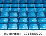 Blue stadium seats with number. Empty plastic chairs in stadium.